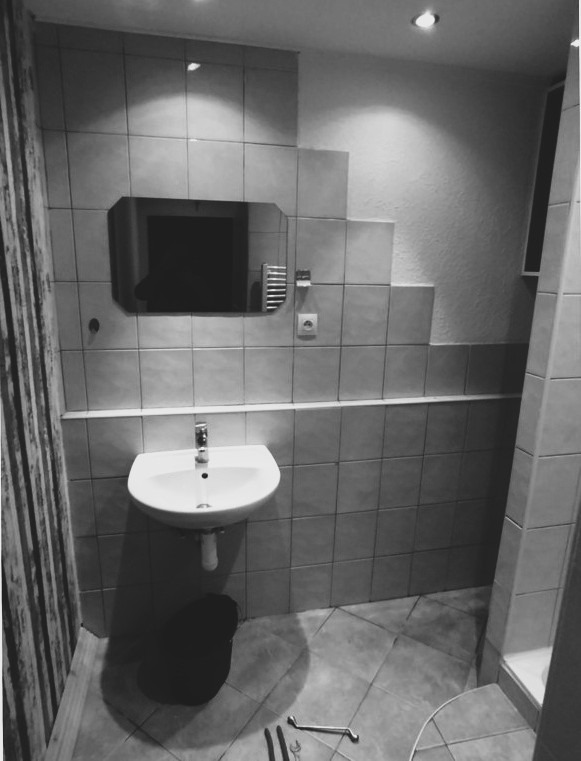 Staršia kúpeľňa pred renováciou – dlažba, jednoduché umývadlo a sprchový kút